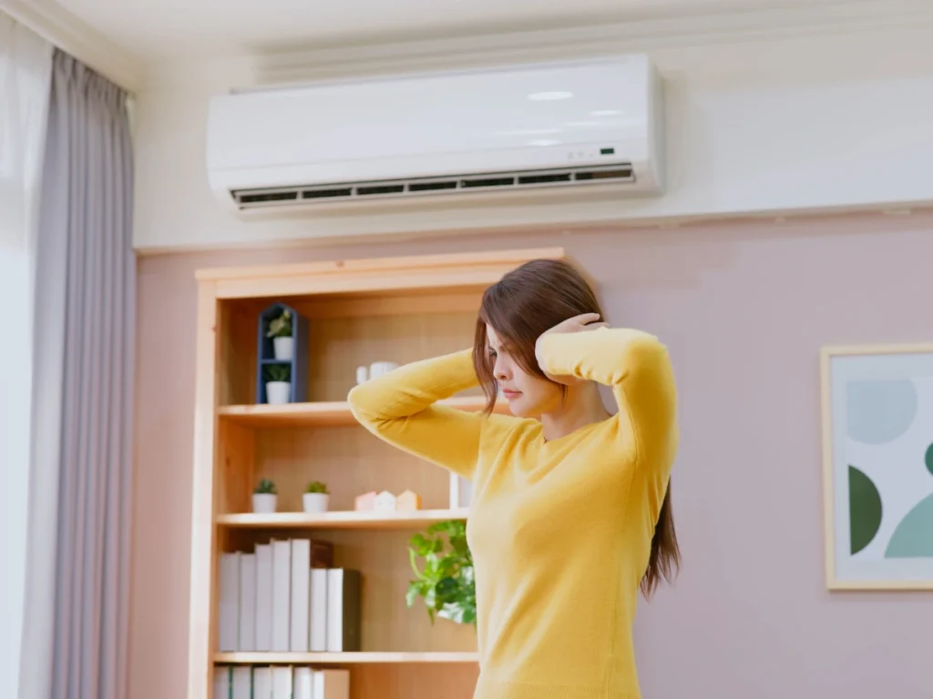 A girl covering her ears because of a noisy AC, a sign it might be time to upgrade your air conditioning system for a quieter home.